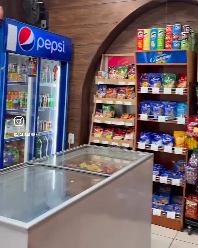 The drinks fridge and the ice cream freezer by the arched doorway
