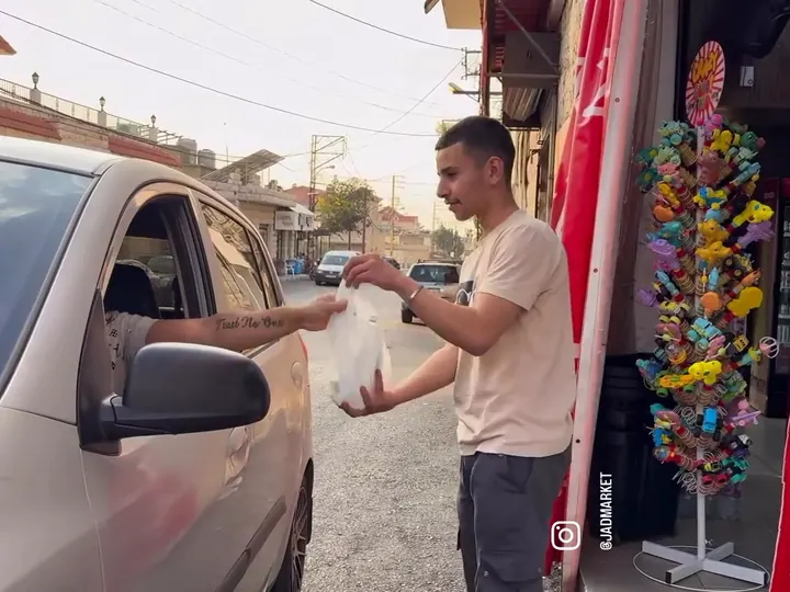 A staff member handing a bag through the car window