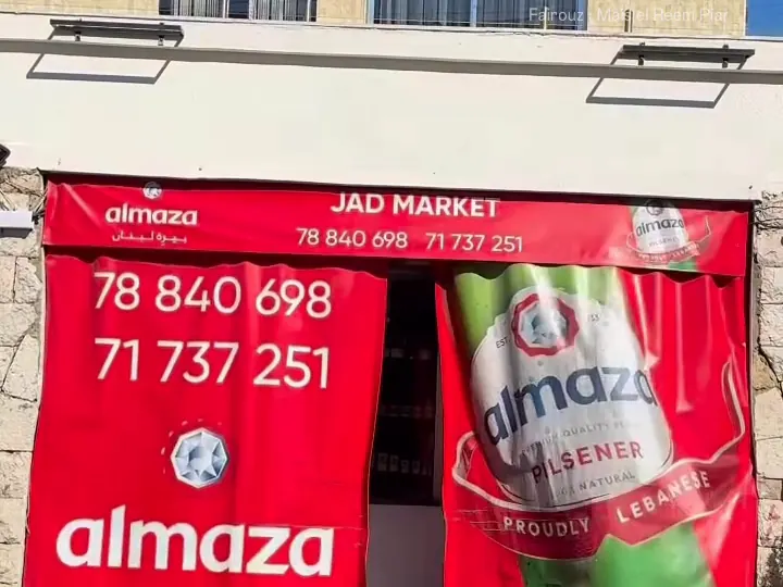 Jad Market's storefront with red banners and phone numbers